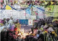  ?? GALIT RODAN THE CANADIAN PRESS FILE PHOTO ?? Flowers, notes and candles are piled high at a vigil on Yonge Street in Toronto in April 2018. Dina Risin, a victim of the van attack, is terrified there are other men like Alek Minassian.