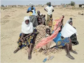  ??  ?? Marginalis­ed: Women and their children sit on a pile of rocks they are to turn into powder for sale to constructi­on workers, at a camp for displaced people at Ouagadougo­u, Burkina Faso. /Reuters