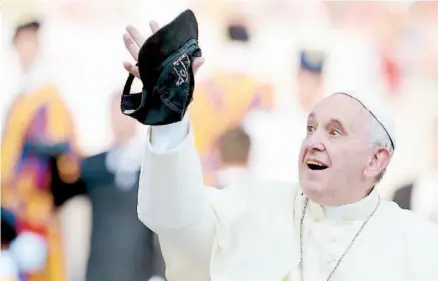  ??  ?? En la víspera de su gira latinoamer­icana, el papa Francisco coge al vuelo una gorra a su llegada a una reunión de la agrupación de la Renovación en el Espíritu Santo en la Plaza de San Pedro de El Vaticano.