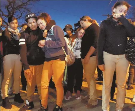  ?? HERALD PHOTOS BY JIM MICHAUD ?? ‘LOVED BY SO MANY’: Friends and classmates of Lee Manuel Viloria-Paulino gather in front of Lawrence High School, above, and light candles, left, for a vigil for the slain high school student.