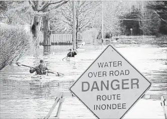  ?? ANDREW VAUGHAN
THE CANADIAN PRESS ?? Local residents return from checking their house surrounded by the waters of the St. John River in Fredericto­n, N.B., Sunday. Swollen rivers continued to rise over the weekend, forcing people from their homes.