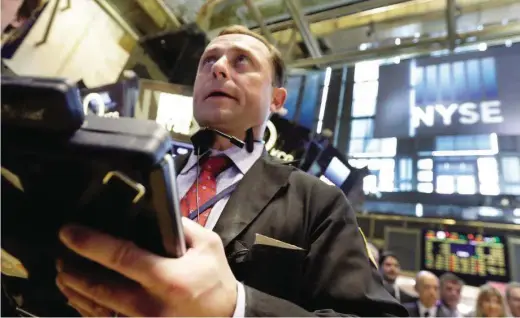  ?? Richard Drew / Associated Press ?? Trader George Baskinger works on the floor of the New York Stock Exchange last month. While U.S. corporatio­ns hold a record $1.82 trillion in cash, the top 1 percent of them have 48 percent of that total.
