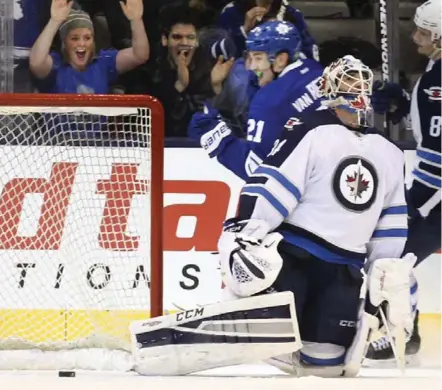  ?? RICHARD LAUTENS/TORONTO STAR ?? Leaf James van Riemsdyk and fans celebrate game-winner behind Jets goalie Michael Hutchinson Saturday night at the Air Canada Centre.