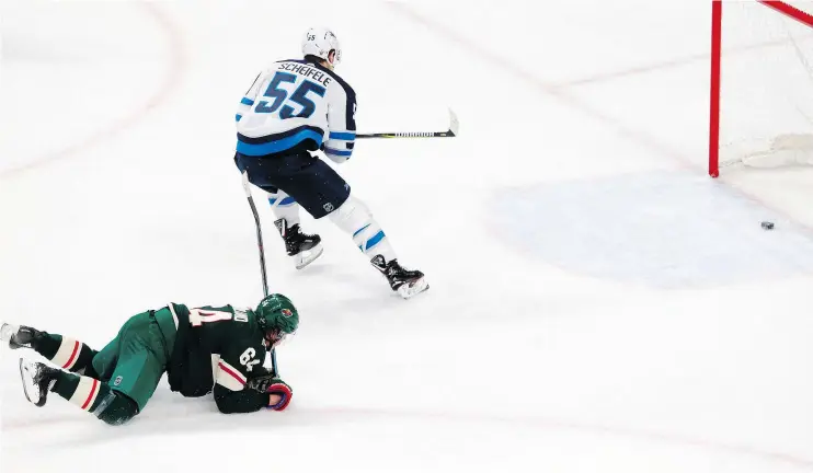  ?? — THE ASSOCIATED PRESS ?? Minnesota Wild forward Mikael Granlund, left, can only watch as Winnipeg Jets centre Mark Scheifele scores an empty-net goal to clinch Game 4 Tuesday.