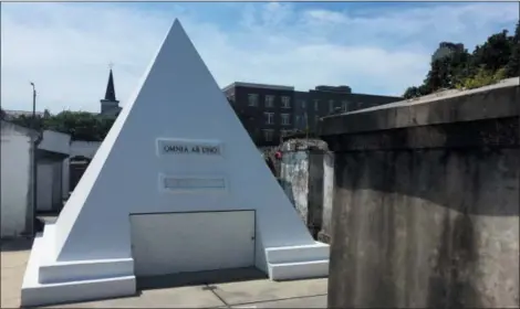  ?? BETH J. HARPAZ — THE ASSOCIATED PRESS ?? Actor Nicolas Cage is alive and well but he owns this gleaming tomb shaped like a pyramid in St. Louis Cemetery No. 1 in New Orleans, pictured in this June 3, 2018 photo. The white 9-foot-tall structure bears the words “omnia ab uno,” which is Latin for “everything from one.”