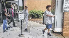  ?? JOHN SPINK / JSPINK@AJC.COM ?? Garrett Ingram (second from left), the father of Demarco Mosley, leaves the Fulton County Jail with family members Tuesday. Ingram told the media in the parking lot of the jail that his son was not driving a stolen car. Mosley is accused of causing a...