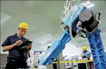  ?? CHEN SHICHUAN / FOR CHINA DAILY ?? A contestant takes part in a competitio­n on the use of industrial robots in Chongqing on Tuesday. A total of 153 skilled workers from Chengdu, Sichuan province, and Chongqing competed in the event to test their abilities in automation, robots and 3D printing.