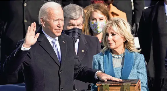  ?? ANDREW HARNIK/AP ?? Joe Biden is sworn in as the 46th president of the United States by Chief Justice John Roberts as Jill Biden holds the Bible.