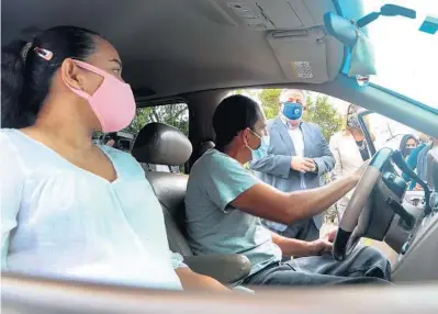  ?? MIKE STOCKER / SOUTH FLORIDA SUN SENTINEL ?? Noubar Afeyan, co-founder of the biotechnol­ogy company Moderna, talks with Luisa and Guillermo Jimenez after they received the Moderna COVID-19 vaccine in their car at the Jessie Trice Community Health Center in Miami on Friday.