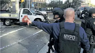  ?? MARTIN SPEECHLEY/THE ASSOCIATED PRESS ?? New York City Police Department police officers respond after several cyclists were run down and killed by a man who began firing a gun after getting out of the truck he was driving.