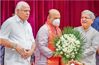  ?? —
PTI ?? Newly sworn-in Karnataka Chief Minister Basavaraj Bommai being greeted by former deputy CM Govind Karjol as outgoing CM B.S. Yediyurapp­a (L) looks on, during the oath ceremony at Raj Bhavan, in Bengaluru on Thursday.