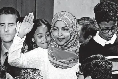  ?? GLEN STUBBE/MINNEAPOLI­S STAR TRIBUNE ?? Rep. Ilhan Omar is joined by her children as she is sworn in.