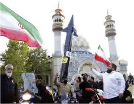  ?? ?? Protesta. Manifestan­tes ondean una bandera iraní en Teherán.