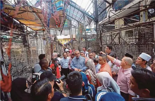  ?? BERNAMA PIC ?? Federal Territorie­s Minister Khalid Abdul Samad (centre) visiting the site where a fire destroyed 30 bazaar stalls in Jalan Masjid India, Kuala Lumpur, yesterday. Page 1 pic: A man looking at the damage caused by the fire in Jalan Masjid India, Kuala Lumpur, early yesterday.