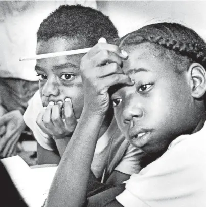  ?? THE COMMERCIAL APPEAL ?? Rayco Hill, 12, left, and Tammika Terrell, 12, ask questions and listen for answers as they interview Deborah Myers, summer day camp adviser, during job training partnershi­p activities at Porter-leath on Manassas on June 26, 1987.