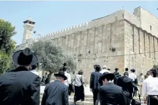  ?? HAZEM BADER/GETTY IMAGES ?? Religious Jews and tourists walk towards the Cave of the Patriarchs, also known as the Ibrahimi Mosque. UNESCO declared the Old City of Hebron in the occupied West Bank a protected heritage site, angering Israel.