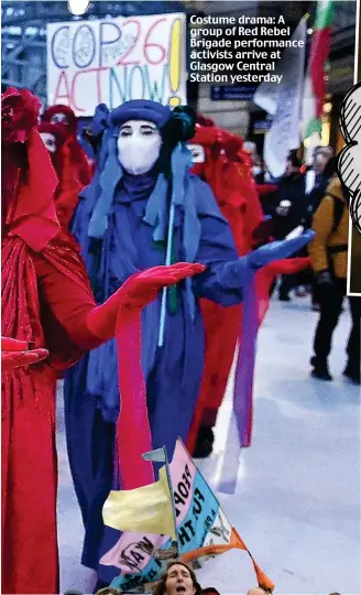  ?? ?? Costume drama: A group of Red Rebel Brigade performanc­e activists arrive at Glasgow Central Station yesterday