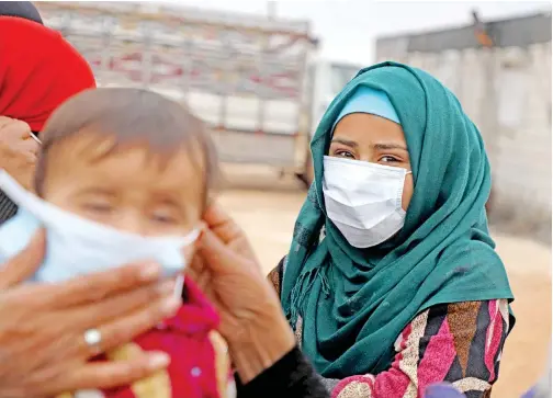  ??  ?? A Syrian youth wears a face mask during an awareness workshop on coronaviru­s (COVID-19) held by Doctor Ali Ghazal at a camp for displaced people in Atme town in Syria’s northweste­rn Idlib province, near the border with Turkey on Saturday.