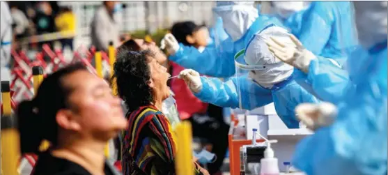  ?? PROVIDED TO CHINA DAILY ?? Residents receive COVID-19 nucleic acid tests at a residentia­l community in Qingdao, Shandong province, on Oct 12 after several cases were reported in the city over the weekend. But as of midday on Oct 13, no additional cases of COVID-19 had been identified and authoritie­s say that the city as a whole is at low risk of community-level spread of the virus.