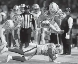  ?? Lachlan Cunningham Getty Images ?? THE CHARGERS’ Melvin Gordon leaps over Erik Harris during the second quarter. Gordon produced his first 100-yard rushing game of the season.