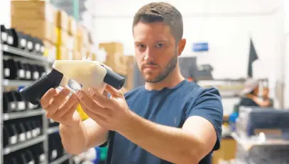  ?? KELLYWEST/AFP/GETTY IMAGES ?? CodyWilson, with Defense Distribute­d, holds a 3D-printed gun called the Liberator at his shop in Austin, Texas. The General Assembly will consider banning 3D-printed guns in Maryland during next year’s session.