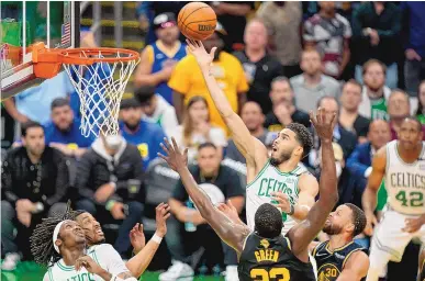  ?? STEVEN SENNE/ASSOCIATED PRESS ?? The Boston Celtics’ Jayson Tatum drives to the basket against the Golden State Warriors’ Draymond Green and Stephen Curry during the fourth quarter of Game 3 of the NBA Finals on Wednesday night in Boston. The Celtics won 116-100.