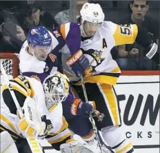  ?? Bruce Bennett/Getty Images ?? Kris Letang, right, tries to clear New York’s Cal Clutterbuc­k from around the Penguins goal in the first period.