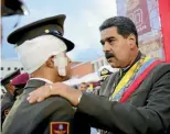  ?? REUTERS ?? Venezuela’s President Nicolas Maduro decorates an injured National Guard soldier during a military parade in Caracas yesterday.