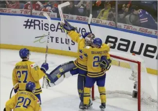  ?? JEFFREY T. BARNES, THE ASSOCIATED PRESS ?? Sweden celebrates a 4-2 victory over the United States following the third period at the world junior hockey championsh­ip Thursday in Buffalo. Next up is the winner between Canada and Czech Republic.