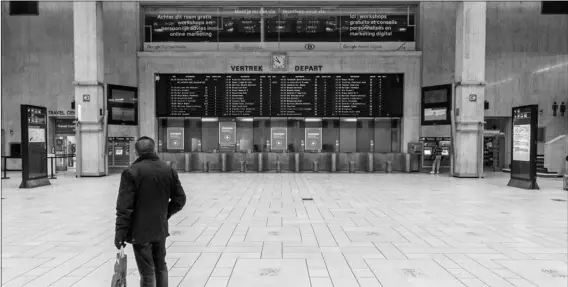  ?? AP PHOTO/OLIVIER MATTHYS ?? A man looks at departure boards at the main hall of the nearly empty Central train station in Brussels, on Monday.