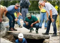  ?? (AP/Richmond Times-Dispatch/Shaban Athuman) ?? Devon Henry (center), owner of the constructi­on company that removed the statue, looks on Thursday as crews search for the time capsule.