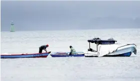  ??  ?? Men on their boats out at sea.