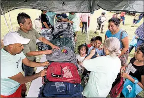  ?? Arkansas Democrat-Gazette/MITCHELL PE MASILUN ?? Volunteers hand out backpacks Saturday during a back-to-school event at the West Central Sports Complex in Little Rock.