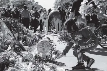  ?? SAMUEL CORUM Getty Images ?? Mourners have been placing flowers at a makeshift memorial to honor Supreme Court Justice Ruth Bader Ginsburg in front of the US Supreme Court on Saturday, a day after she died after a battle with pancreatic cancer.