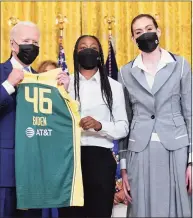  ?? Susan Walsh / Associated Press ?? President Joe Biden, left, poses for a photo with Seattle Storm's Jewell Loyd, center, and Breanna Stewart, right, on Monday in Washington.