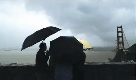  ?? Scott Strazzante / The Chronicle ?? On a rainy Sunday, Li Wei of Shangai visits the Vista Point overlookin­g the Golden Gate Bridge on the Marin County side.