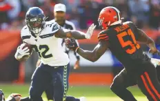  ?? GREGORY SHAMUS/GETTY IMAGES ?? Chris Carson of the Seahawks holds off Mack Wilson of the Browns in Cleveland Sunday. Seattle won 32-28.