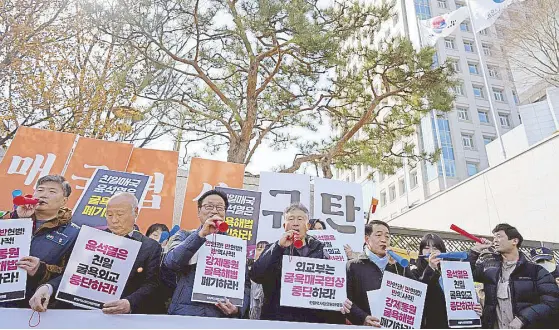  ?? AP ?? Members of civic groups blow horns during a rally against the South Korean government’s plan to raise local civilian funds to compensate those who won damages in lawsuits against Japanese companies that enslaved them during Tokyo’s 35-year colonial rule of the Korean Peninsula. Banners read ‘Discard humiliatin­g solution to forced labor issue.’