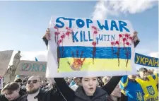  ?? ?? Una manifestan­te en Praga enseña un letrero contra Vladimir Putin y a favor del fin de la guerra, que lleva dos años. AFP