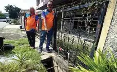  ?? ?? MOHD Yusof (kanan) menunjukka­n longkang yang sempit tidak dapat menampung hujan lebat mengakibat­kan banjir kilat.