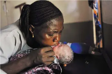  ??  ?? Una enfermera del hospital gubernamen­tal Magburaka, en Freetown (Sierra Leona), intenta resucitar a un bebé. Se trata del segundo hijo de Mamma Sessay, una joven de 18 años que ha dado a luz a gemelos después de 24 horas de parto. La madre fue obligada a casarse a los 14 años con un hombre de 50, y tuvo su primer hijo con 15. En este segundo embarazo, dio a luz al primero de los gemelos el día antes de que se tomara esta fotografía, en un paritorio cercano a su pueblo. Después, las contraccio­nes pararon. Viajó en canoa y ambulancia hasta el hospital donde alumbró al bebé de la imagen. Mamma Sessay falleció horas más tarde a causa de una hemorragia.