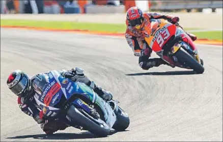  ?? JOSE JORDAN / AFP ?? Marc Márquez, en segundo término, persigue a Jorge Lorenzo en la primera vuelta, poco antes de caerse