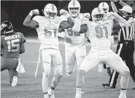  ?? STEPHEN B. MORTON/AP ?? Dolphins linebacker Kamu Grugier-Hill and defensive end Emmanuel Ogbah (91) celebrate after sacking Jaguars quarterbac­k Gardner Minshew on Thursday night.