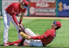  ?? Chris O'meara / Associated Press ?? Philadelph­ia first baseman Rhys Hoskins, right, tore the ACL in his left knee Thursday. He’s expected to miss significan­t time.