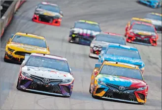  ?? WADE PAYNE/AP PHOTO ?? Denny Hamlin (11) leads Kyle Busch (18) and others down the straight during the NASCAR Cup race on Saturday night at Bristol, Tenn. Hamlin won the race.