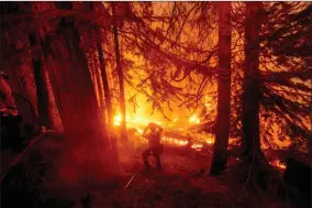  ?? AP PHOTO BY NOAH BERGER ?? In this Sept. 7, 2020, file photo, a firefighte­r battles the Creek Fire in the Shaver Lake community of Fresno County, Calif. California will authorize $536 million for wildfire mitigation and forest management projects before the worst of the fire season strikes later this year, Gov. Gavin Newsom and legislativ­e leaders said Thursday, April 8.