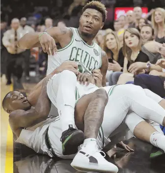  ?? AP PHOTO ?? HARD FEELINGS: Marcus Smart is held back during an altercatio­n with Cleveland’s J.R. Smith on Saturday, for which the Celtics guard was fined $25,000.