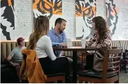  ?? (AP Photo/ Chris O’Meara) ?? Customers drink coffee Wednesday at the Blind Tiger Cafe in Tampa, Fla. Consumer inflation remained persistent­ly high last month, boosted by gas, rents, auto insurance and other items, the government said Wednesday.