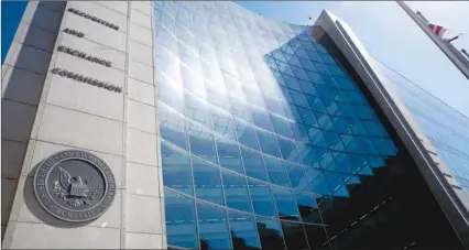  ??  ?? The Securities and Exchange Commission stands in Washington, DC. The US securities regulator is set to review this month rules on corporate democracy, setting it up for a clash with investors who worry the agency will side with companies to diminish voting rights on charged issues like climate change and gun violence.
