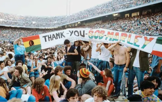  ?? ?? A SAN SIRO CON PINO DANIELE Sopra, i quasi 100 mila che il 27 giugno del 1980 a San Siro assistette­ro alla tappa milanese dell’Uprising tour di Bob Marley. Ad aprire il concerto fu Pino Daniele (1955-2015, a sinistra, quella sera sul palco) con
A me me piac’ ‘o blues.